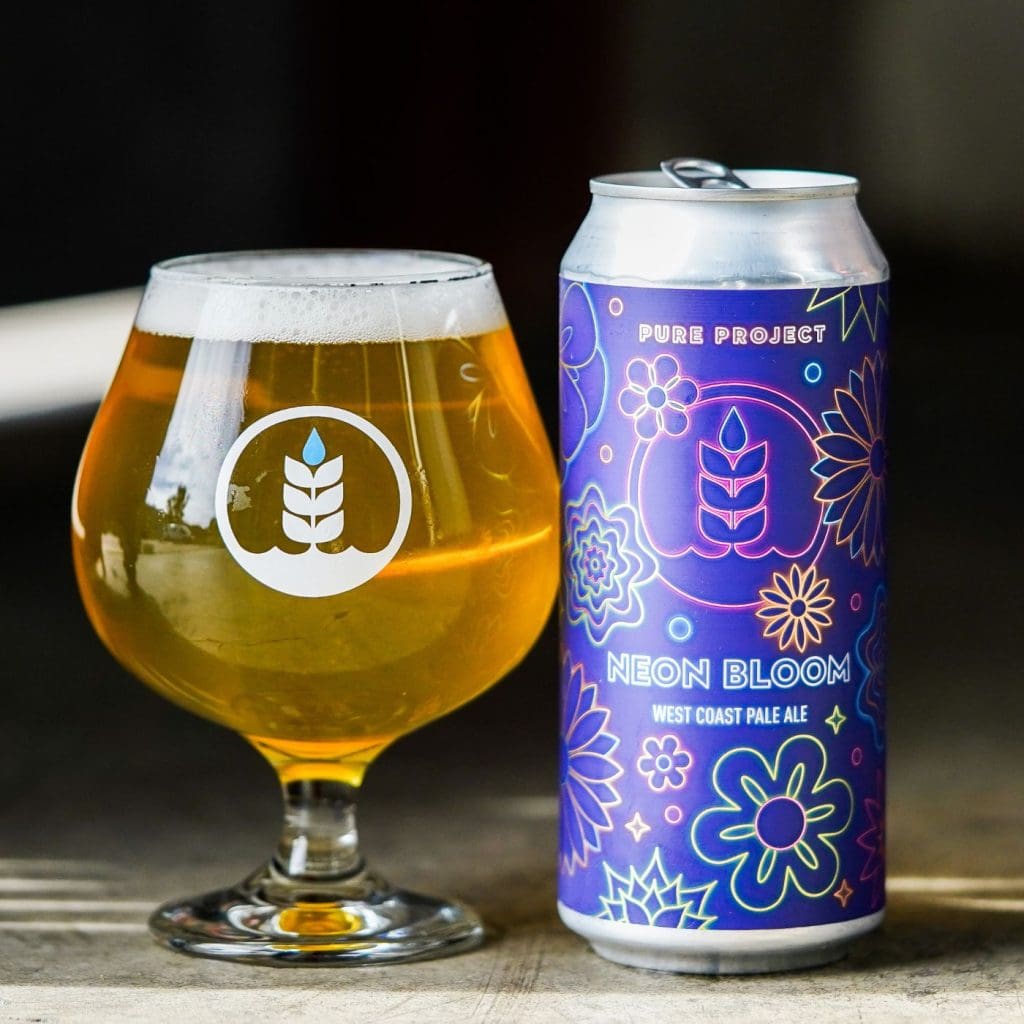 Can of Pure Project Neon Bloom West Coast pale ale next to glass of beer