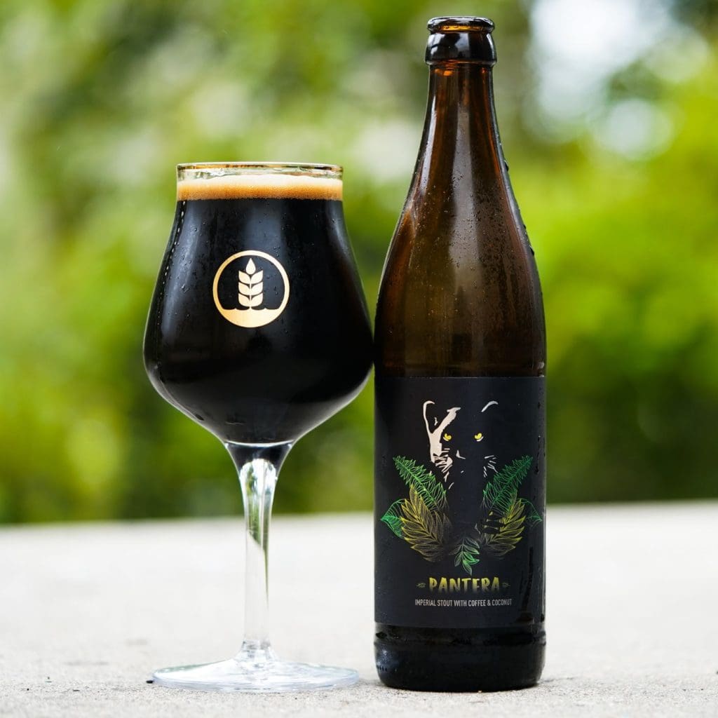 Bottle of Pure Project Pantera Imperial Stout next to glass of beer